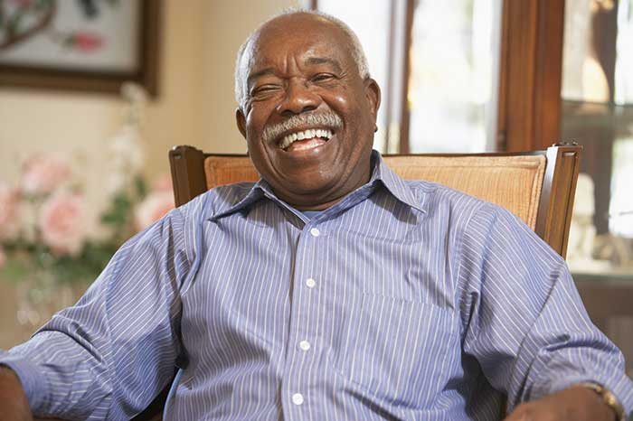 A senior man is smiling at Stonebriar Facial & Oral Surgery in Frisco, TX
